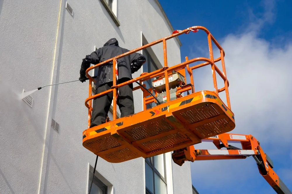 Man power washing from a lift Oh paneless Man power washing from a lift Oh paneless