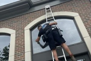 Man on ladder cleaning window panless Experience westlake oh Man cleaning window High rise Oh